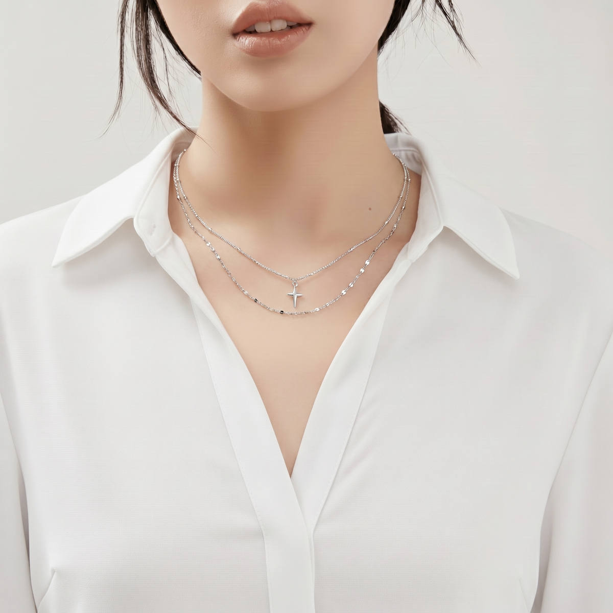 Glossy Geometric Cross Necklace worn by a human model
